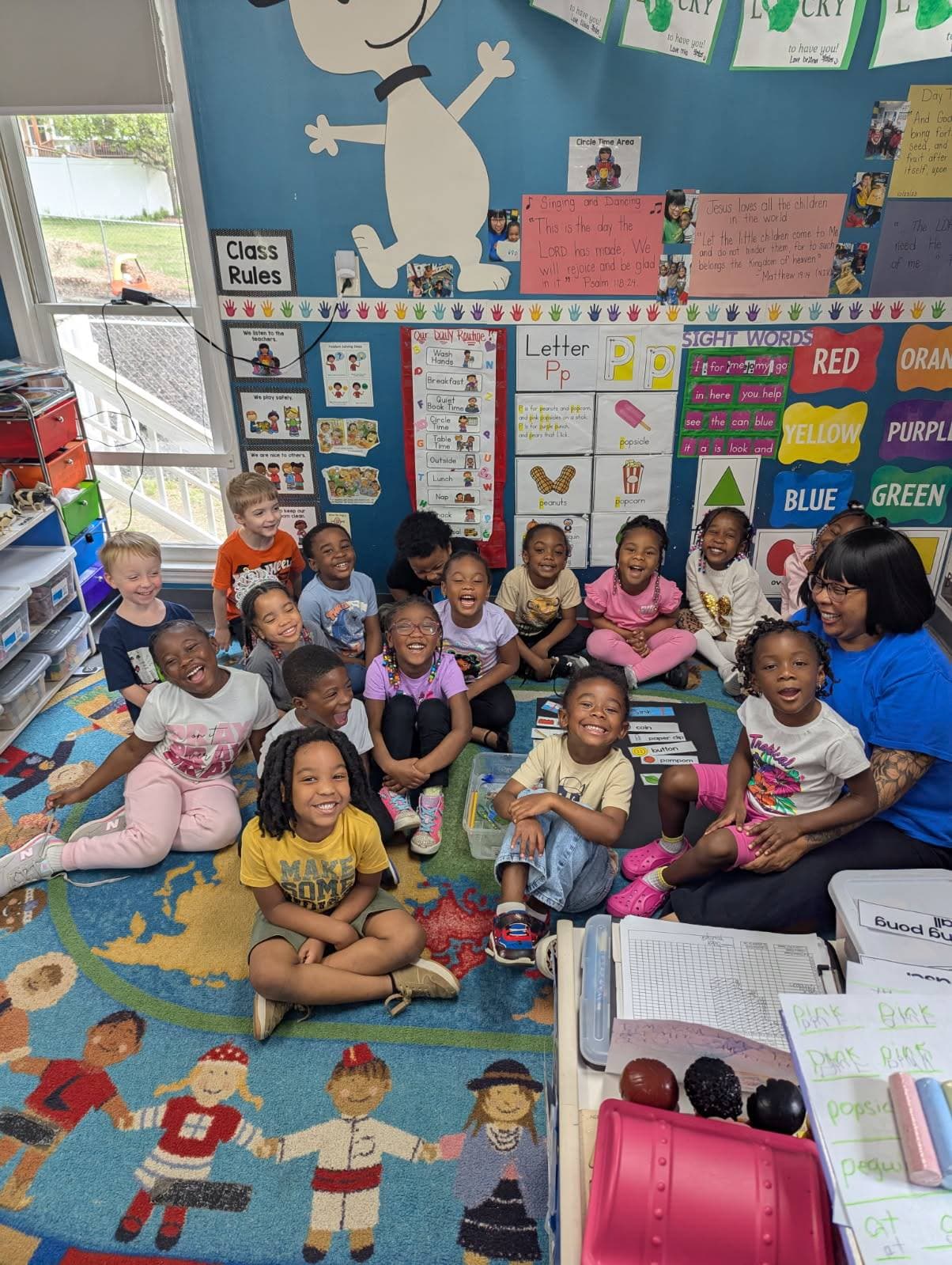 A Falls Academy teacher working alongside children in the classroom